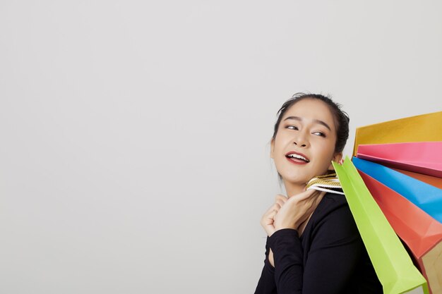 joven asiática con coloridos bolsos de compras