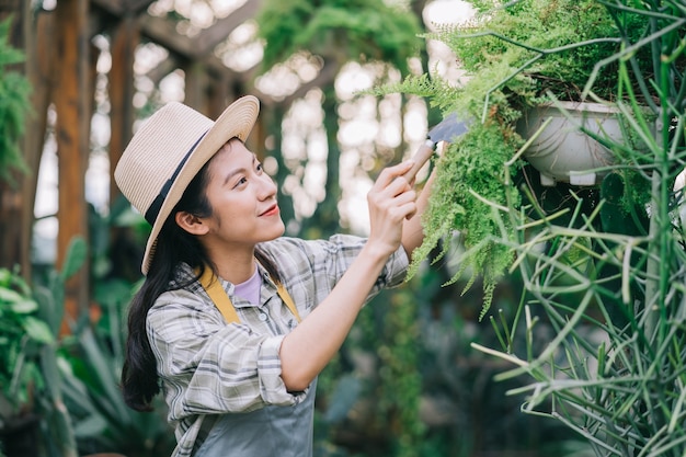 Joven asiática cuida el jardín