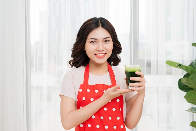 Joven asiática disfruta de un batido vegetariano saludable para perder peso y desintoxicarse
