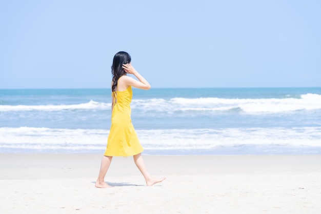 Joven asiática disfrutando de las vacaciones de verano en la playa