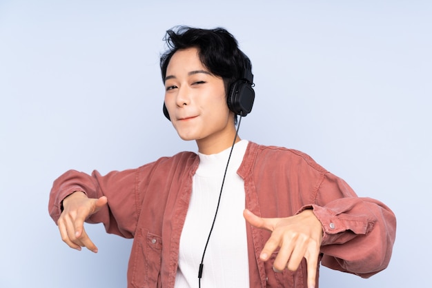 Joven asiática escuchando música y bailando