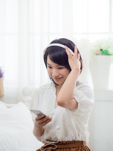 Joven asiática escuchando música en casa