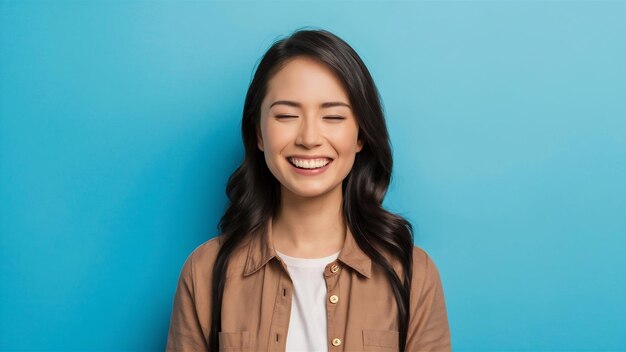 Una joven asiática con una expresión positiva sonríe ampliamente vestida con ropa casual y cierra tu