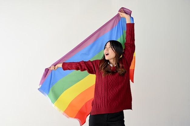 Una joven asiática feliz con una bandera LGBT del arco iris libertad derechos humanos