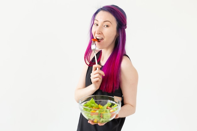 Joven asiática fitness chica con cabello teñido sosteniendo en las manos ensalada de verduras concepto de alimentación saludable