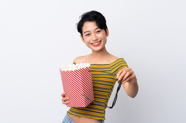 Joven asiática con gafas 3d y sosteniendo un gran cubo de palomitas de maíz