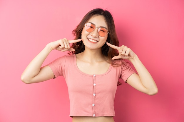 Joven asiática con gafas con expresión alegre en una rosa