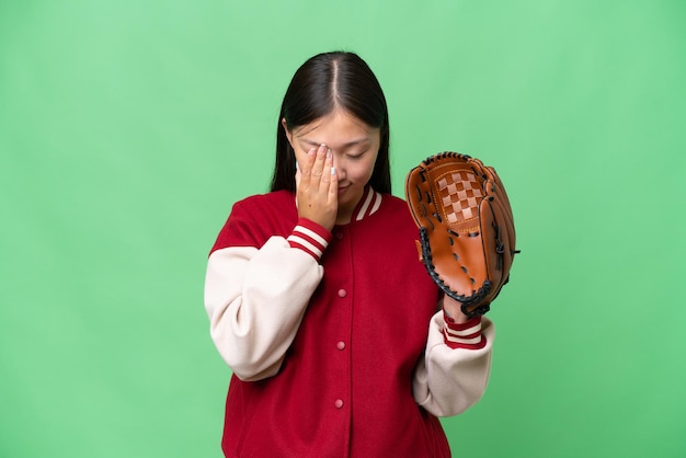 Joven asiática con guante de béisbol sobre un fondo aislado con expresión cansada y enferma