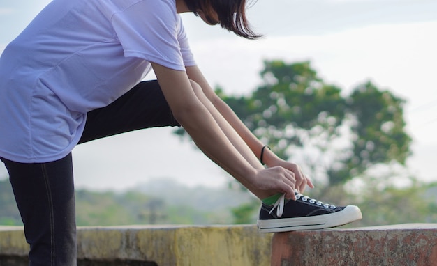 Joven asiática ha preparado sus zapatos antes de correr y trotar por la mañana