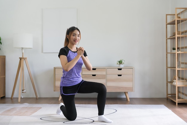 Joven asiática haciendo ejercicio y estirando músculos para entrenar un estilo de vida saludable en casa