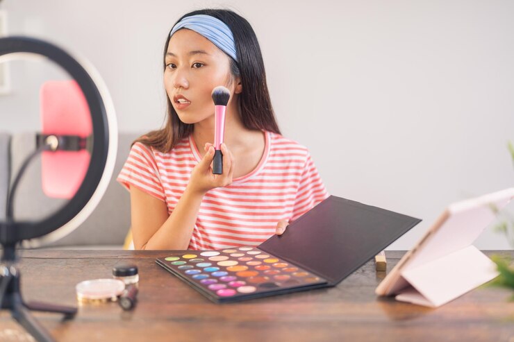 Foto joven asiática haciendo un video de cómo se maquilla