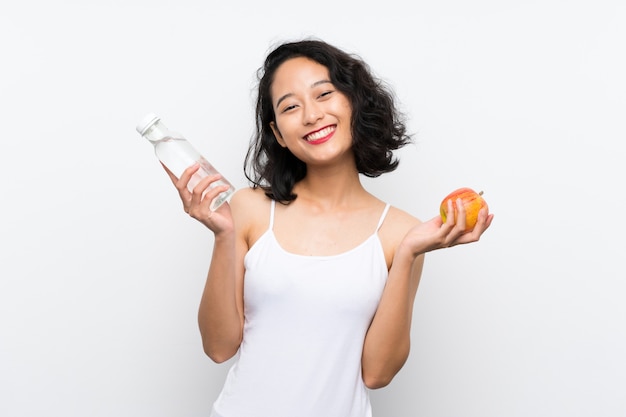 Joven asiática con una manzana sobre fondo blanco aislado