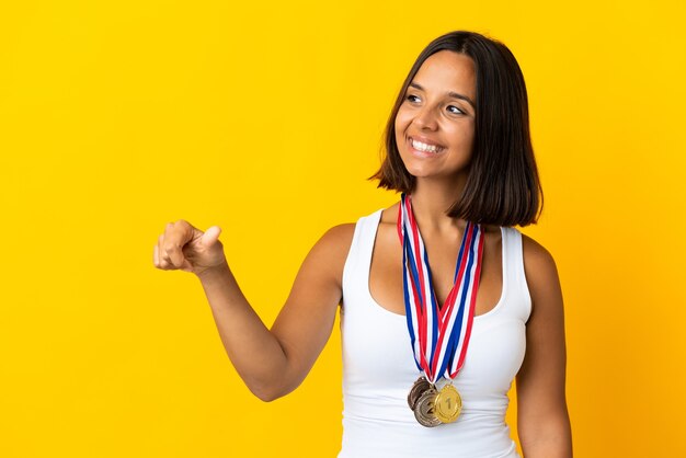 Joven asiática con medallas aislado en la pared blanca dando un pulgar hacia arriba gesto