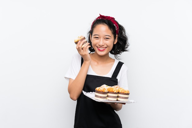 Joven asiática con un montón de pastel de muffin