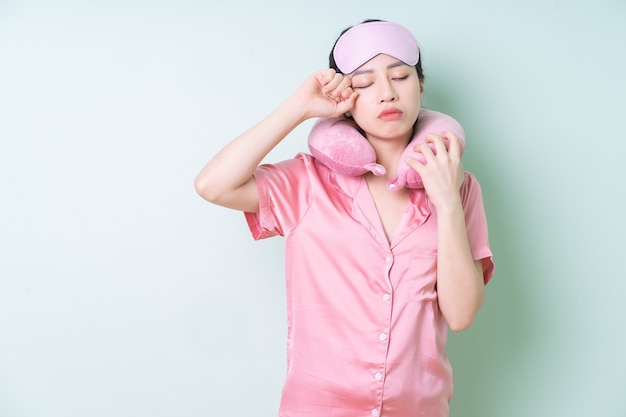 Foto joven asiática en pijama sobre fondo verde