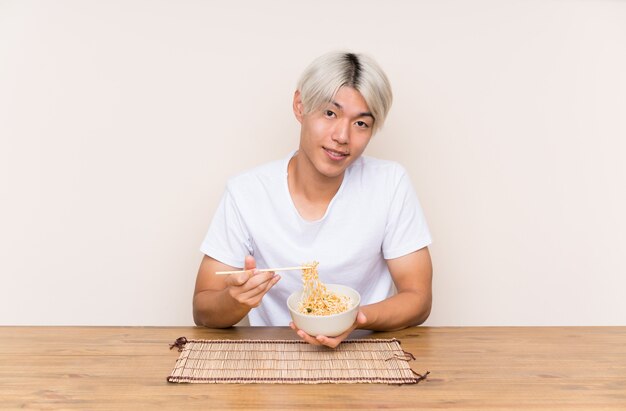 Joven asiática con ramen en una mesa