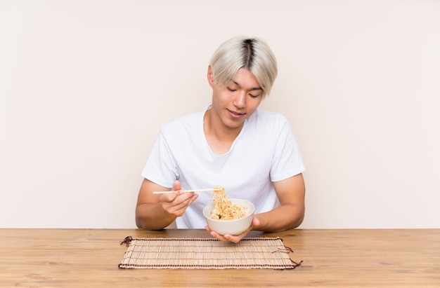 Joven asiática con ramen en una mesa