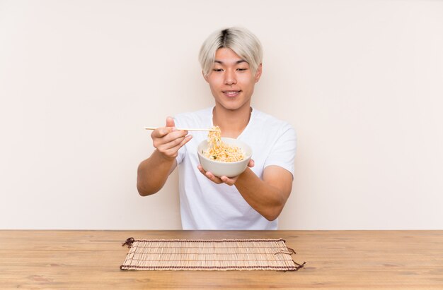 Joven asiática con ramen en una mesa