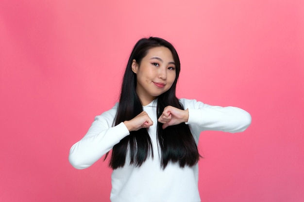 Joven asiática segura de sí misma señalando con los dedos a sí misma orgullosa de su éxito de logros en rosa