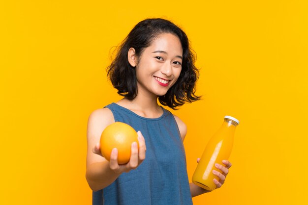 Joven asiática sosteniendo una naranja