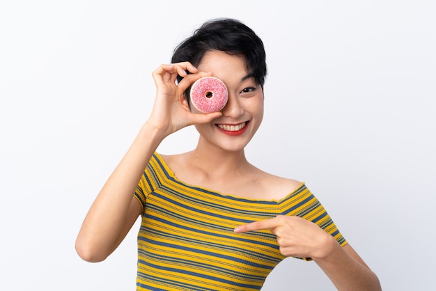 Joven asiática sosteniendo una rosquilla y feliz