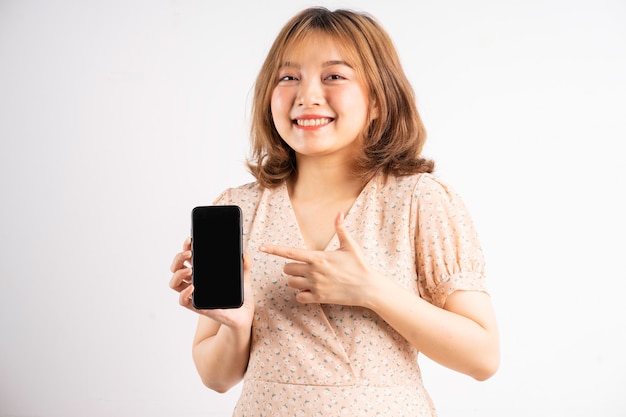 Joven asiática sosteniendo el teléfono con expresiones y gestos en blanco