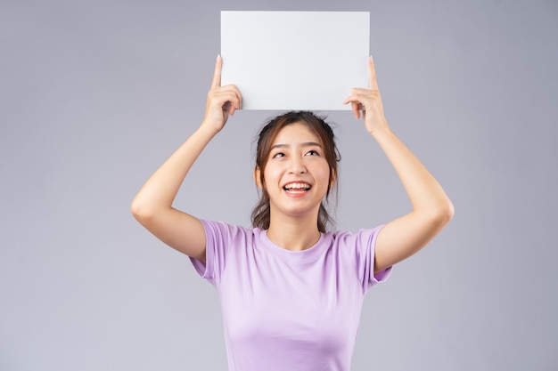 Joven asiática con tablero blanco vacío