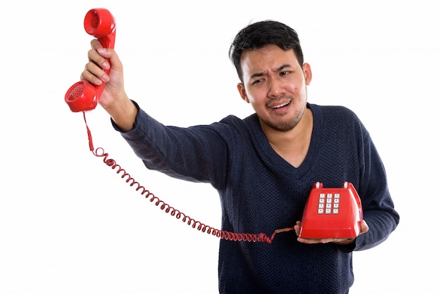 joven asiática con teléfono viejo mirando molesto