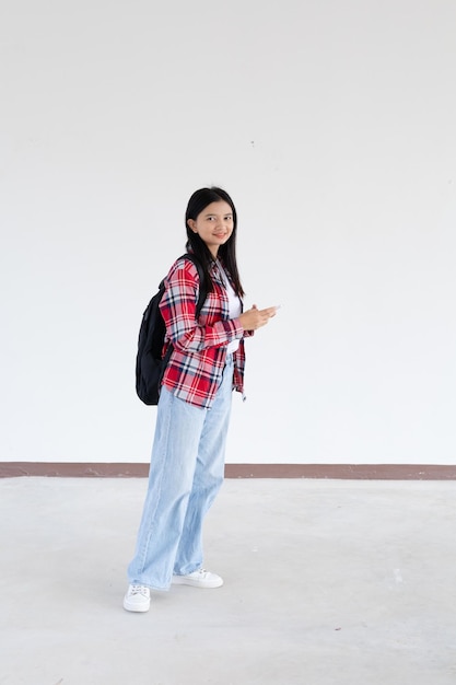 Una joven asiática usando un teléfono inteligente en la escuela