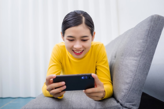 Joven asiática viendo algo en el móvil