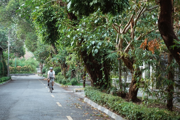 Joven asiático andar en bicicleta de carretera