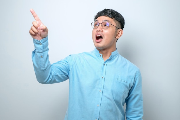 Un joven asiático con una camisa informal apuntando hacia adelante Mirando a la cámara hace que elijas tu gesto