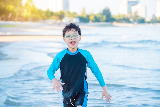 Joven asiatico corriendo en la playa