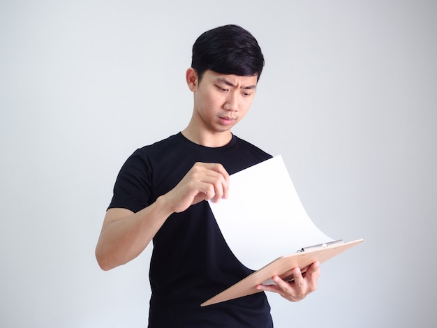 Joven asiático documento abierto en portapapeles de madera cara seria en blanco aislado, concepto de trabajador