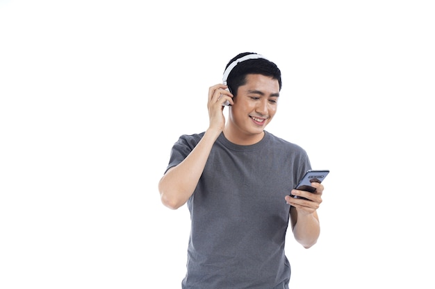 Joven asiático escuchando música y cantando en su teléfono