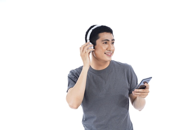 Joven asiático escuchando música y cantando en su teléfono