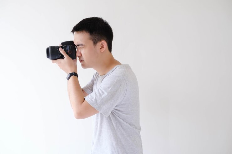 Un joven asiático está fotografiando y dirigiendo una cámara DSLR