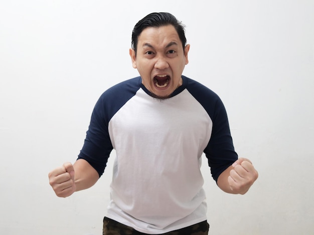 Joven asiático gritando fuerte debido a la ira concepto de rabia agresión frustración loca