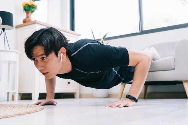 Joven asiático haciendo ejercicio en casa