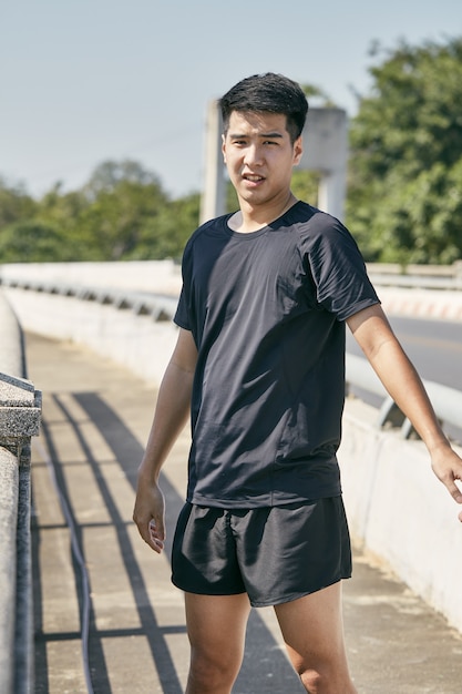 Joven asiático haciendo ejercicio en la ciudad