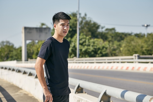 Joven asiático haciendo ejercicio en la ciudad