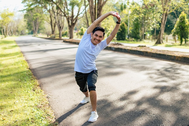 Joven asiático haciendo ejercicio de estiramiento preparándose para correr en la naturaleza Estilo de vida saludable