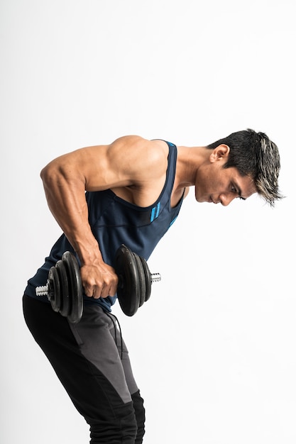 Joven asiático levanta pesas para entrenar los músculos de la espalda y los tríceps