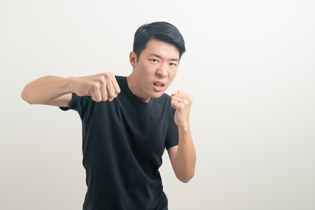 Joven asiático con mano de perforación sobre fondo blanco.