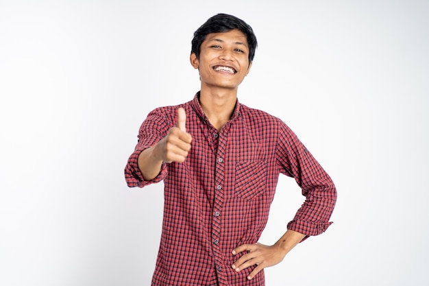 Joven asiático mostrando los pulgares hacia arriba con dientes sonrientes