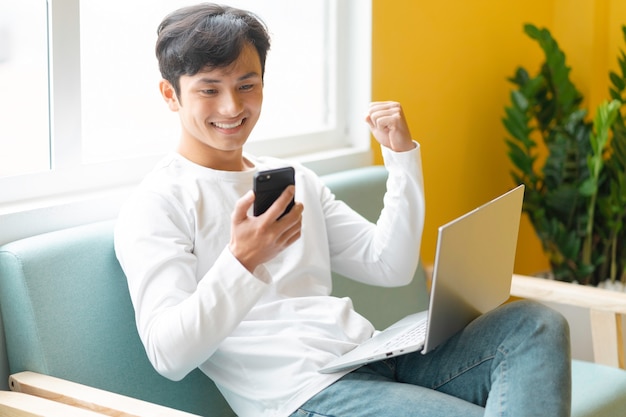 Joven asiático sentado trabajando en casa