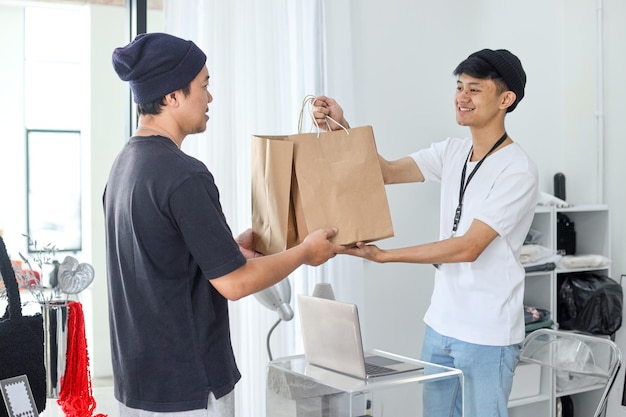 Joven asiático sirviendo al cliente en una tienda