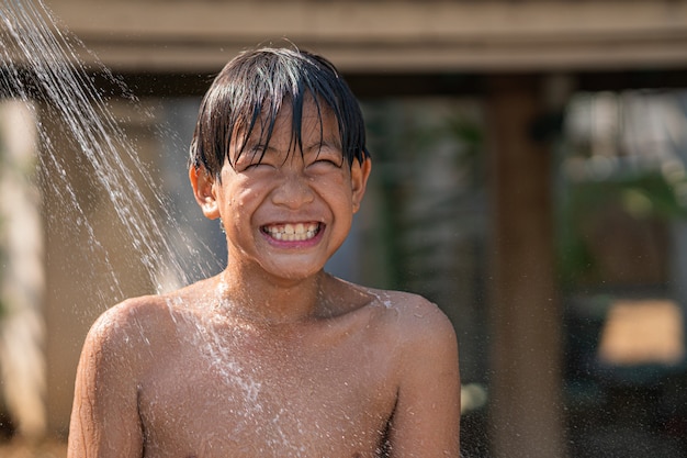 Joven asiático sonriendo mientras se baña en la piscina