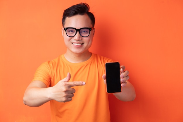Joven asiático sosteniendo el teléfono con una expresión emocionada