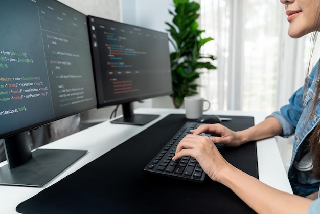 Joven asiático en TI creando con el teclado de información en línea en PC Stratagem